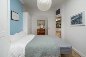 a bedroom with a bed and a blue wall at ALTIDO Eclectic flat with Garden in London