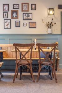 two wooden chairs sitting next to a wooden table at The Old Mill Inn in Dearham