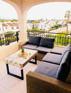 een patio met 2 banken en een tafel op een balkon bij Bellavista V Cabo Roig in Cabo Roig