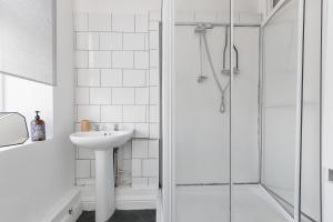 uma casa de banho branca com um lavatório e um chuveiro em Convenient 2-Bed Apartment - Ideal for Contractors & Working Away, Free Parking, Pet Friendly, Netflix em Sheffield