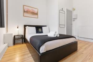 um quarto com uma cama com um edredão preto e branco em Convenient 2-Bed Apartment - Ideal for Contractors & Working Away, Free Parking, Pet Friendly, Netflix em Sheffield