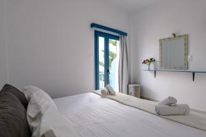 a bedroom with a bed with a mirror and a window at Porto Bello di Paros in Parikia