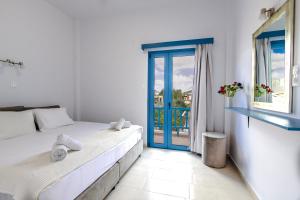 a bedroom with a bed and a window with a view at Porto Bello di Paros in Parikia