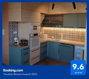 a kitchen with blue cabinets and white appliances at Blonde River Apartman Móra Szeged in Szeged