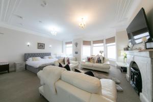 Kelvin House في فليتوود: غرفة معيشة بأثاث أبيض وموقد