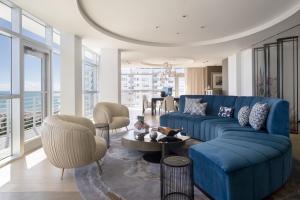 a living room with a blue couch and chairs at The Ritz-Carlton South Beach in Miami Beach
