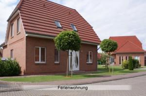 a brick house with a red roof on a street at Ferienwohnung Hafftraum in Liepgarten