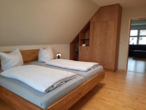 Habitación con 2 camas individuales y suelo de madera. en Ferienwohnung Hafftraum, en Liepgarten