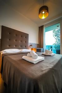 a bedroom with a large bed with two towels on it at ABN Residence in Poreč