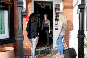 tres mujeres de pie en la puerta de un edificio en Bryn Woodlands House, en Colwyn Bay