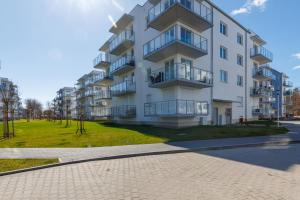 an apartment building with balconies and a park at Coast Breeze Apartment by Renters in Kołobrzeg