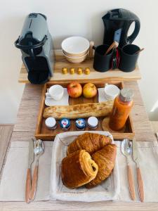 a table with a tray of bread and a mixer at Le Nid Douillet in Plancher-Bas