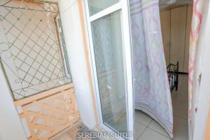 a window in a room with a curtain at Serebian Suites in Mombasa +14 photos