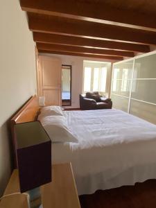 een slaapkamer met een groot wit bed en een bank bij La Luna nei Sassi in Matera