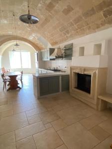 cocina grande con chimenea y mesa en La Luna nei Sassi en Matera