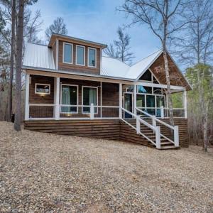 a small house with a large porch on a home at Haven Hideaway, New Luxury Cabin w/ hot tub and fire pit in Broken Bow