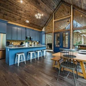 a kitchen with blue cabinets and a wooden ceiling at Haven Hideaway, New Luxury Cabin w/ hot tub and fire pit in Broken Bow