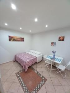 a bedroom with a bed and a table at San Ciro's apartment in Portici