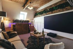 sala de estar con TV de pantalla plana grande en Le Duplex de l'Etoile home cinéma jacuzzi et sauna privatif, en Longmesnil