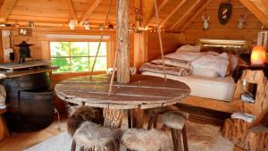 a room with a bed and a table in a cabin at KOTA Finlandais bien être , les gîtes de l'étang in La Chapelle
