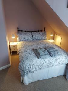 a bedroom with a large bed with two night stands at Black Cat Cottage in Moffat
