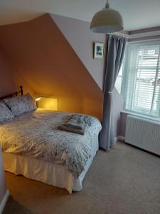 a bedroom with a large bed with a sloped ceiling at Black Cat Cottage in Moffat