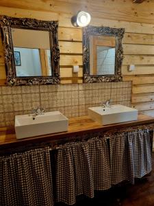 uma casa de banho com 2 lavatórios e um espelho em Wolf & Sheep Nature & Adventure em Podgorica