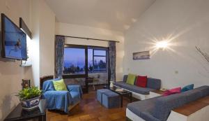 sala de estar con sofá, sillas y TV en Apartamentos Azul Mar en Albufeira