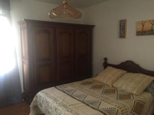 um quarto com uma cama e um armário de madeira em Vista Alegre em Zarautz