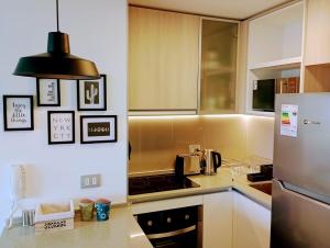 a kitchen with a refrigerator and a counter top at Apartamento cómodo y espectacular en Concón !! in Concón