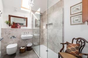 a bathroom with a shower and a toilet and a sink at Sarah's - A townhouse apartment in Georgian Holt in Holt