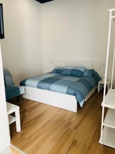 Schlafzimmer mit einem Bett mit blauer Bettwäsche und blauen Kissen in der Unterkunft BnB My Way Toledo in Neapel