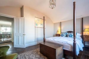 a bedroom with a canopy bed and a table at Sarah's - A townhouse apartment in Georgian Holt in Holt