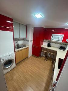 una piccola cucina con armadi rossi e lavandino di Luxury Esther Benidorm a Benidorm