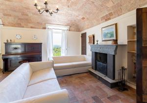 un soggiorno con divano e camino di Casa di nonna Ines 2 - Hideaway in Monferrato con Vista sulle Colline e Piscina a Gabiano