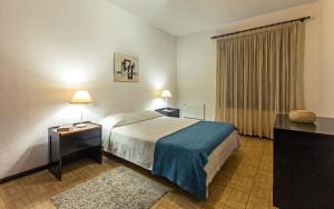 a hotel room with a bed and two tables and a window at Apartamentos Azul Mar in Albufeira