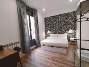 1 dormitorio con cama, mesa y escritorio en Apartamentos Margarita by gaiarooms, en Salamanca