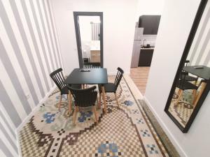 comedor con mesa negra y sillas en Apartamentos Margarita by gaiarooms, en Salamanca