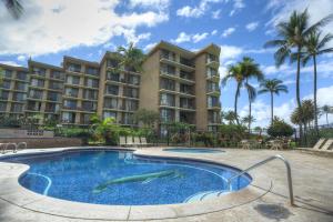 a swimming pool with two dolphins in front of a hotel at Kauhale Makai 506 in Kihei
