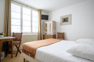 een slaapkamer met een bed, een bureau en een raam bij L'Hippocampe in La Flotte