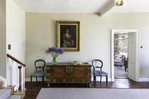uma sala de estar com uma mesa e duas cadeiras em Butley Priory Farmhouse em Woodbridge