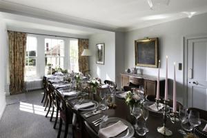 uma grande sala de jantar com uma mesa longa e cadeiras em Butley Priory Farmhouse em Woodbridge
