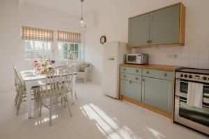 cocina con mesa y sillas y cocina con fogones en Butley Priory Cottage en Woodbridge