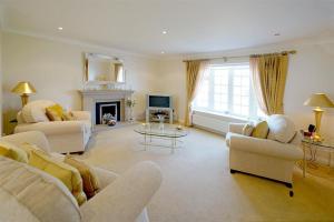 a living room with white furniture and a fireplace at Marie-Lyn in Penrhyn Bay