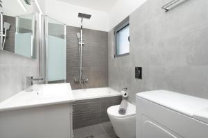 a white bathroom with a sink and a toilet at Luna Apartment by A&D Properties in Porto Rafti +18 photos