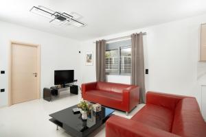a living room with a red couch and a table at Luna Apartment by A&D Properties in Porto Rafti