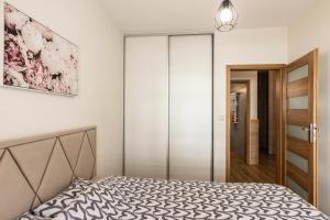 um quarto com uma cama e uma porta de vidro deslizante em Apartament 66 Zator em Zator