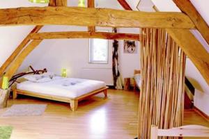 um quarto com uma cama grande num sótão em L'Etoile de Forges em Longmesnil