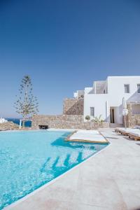 a swimming pool in front of a white building at Arocaria Mykonos in Mikonos