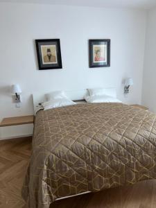 a bedroom with a bed with two pictures on the wall at Villa Relax in Stresa